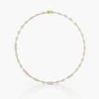 A delicate yellow gold tennis necklace with small round-cut diamonds, arranged in a circular shape against a clean white background.